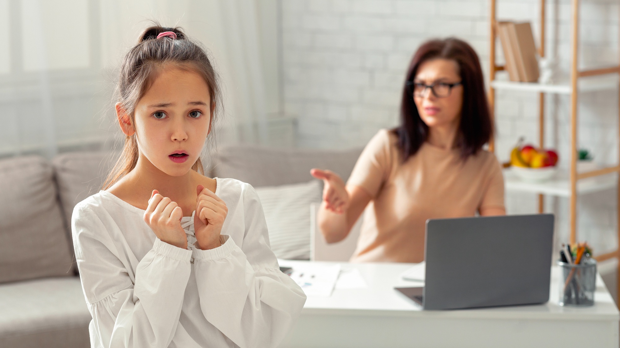 Scared teen girl feeling lonely and neglected, being scolded by her angry tired working mother at